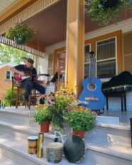 Musiician playing on a large porch in Grafton